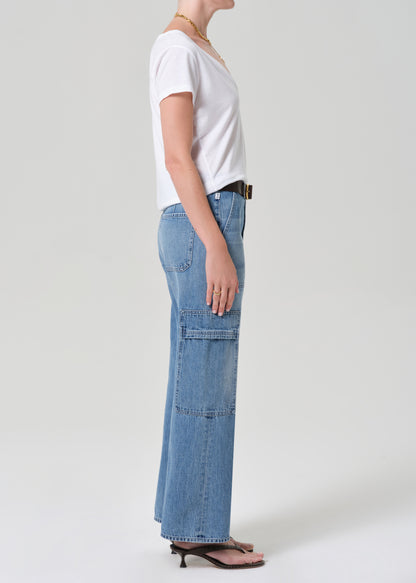 Person wearing a white t-shirt and blue jeans with a belt on a plain background