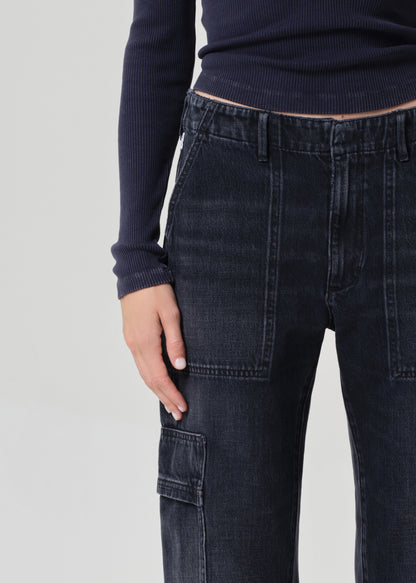 Person wearing a navy long-sleeve top and dark wash wide-leg jeans on a grey background