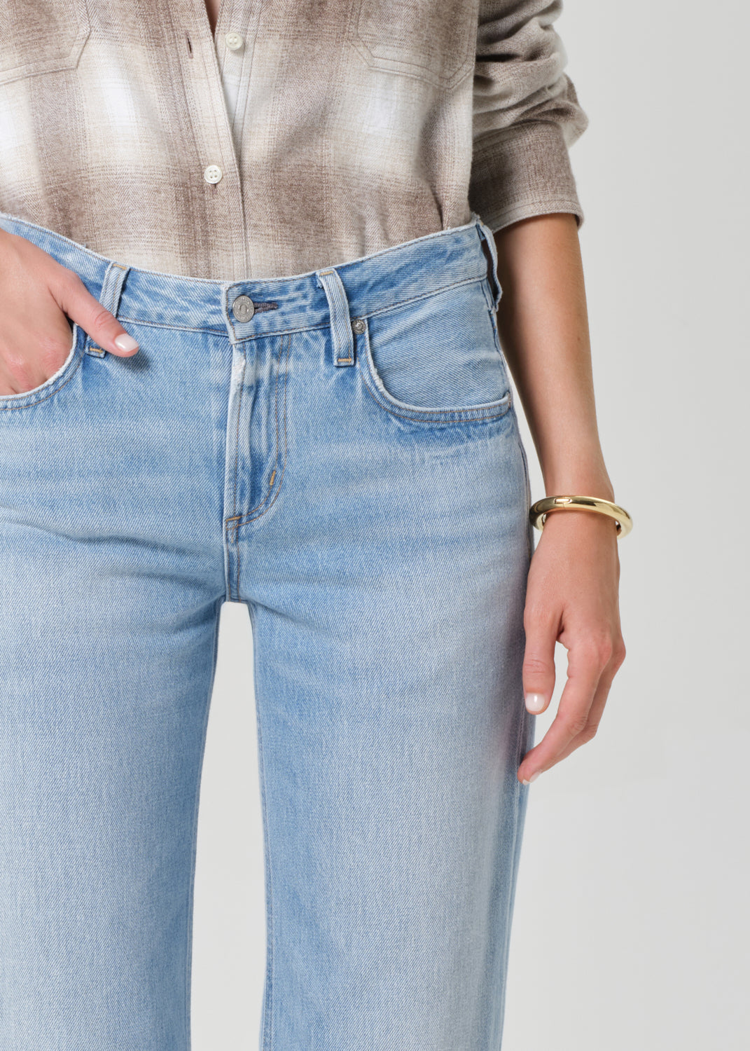 Light blue jeans worn by a person on a plain background
