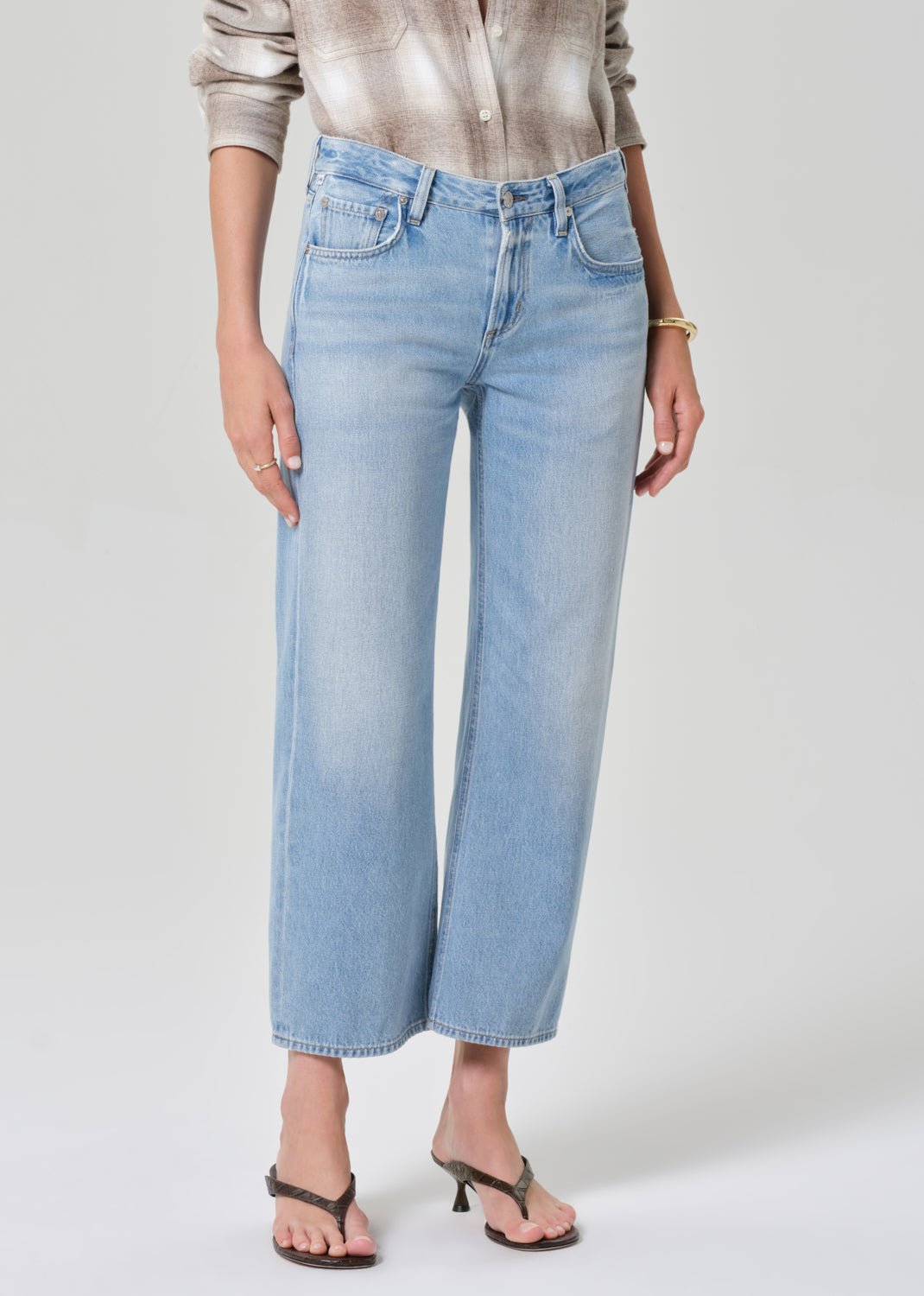 Person wearing light blue jeans on a plain background