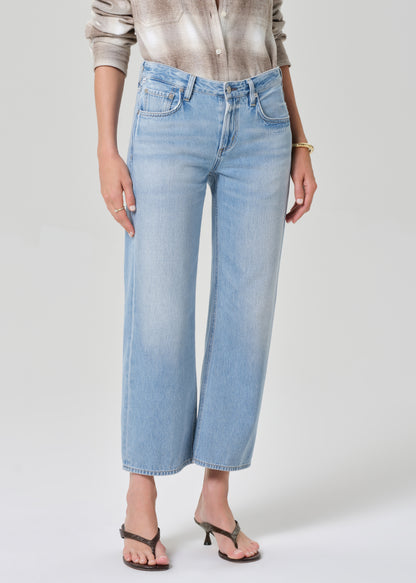 Person wearing light blue jeans on a plain background