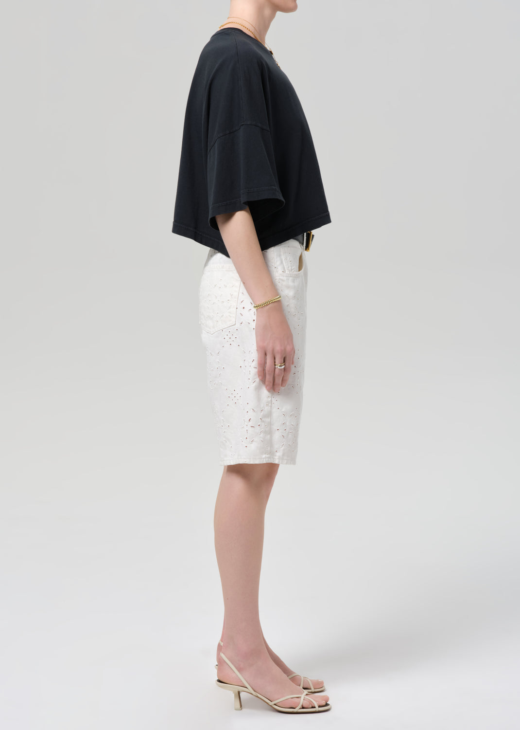 Person wearing a black top and white shorts on a plain background