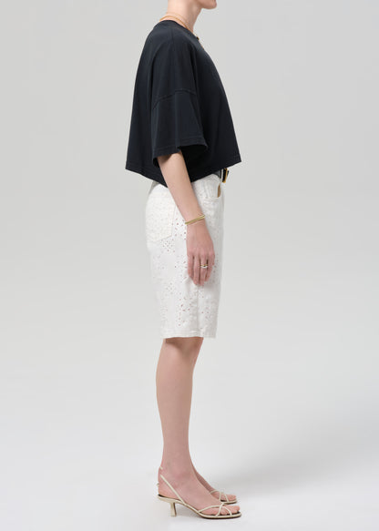 Person wearing a black top and white shorts on a plain background