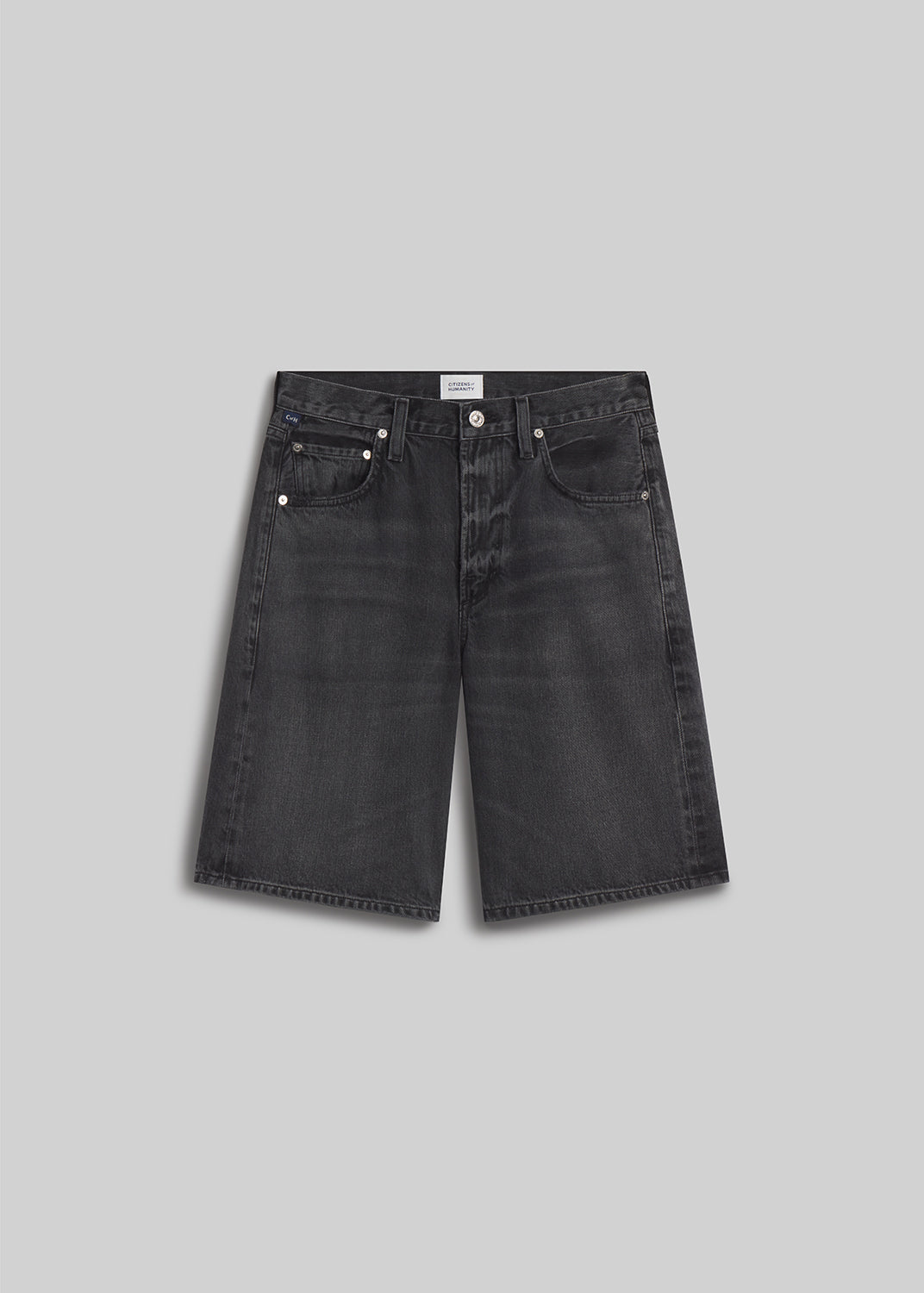 Vintage black denim Bermuda shorts on grey background