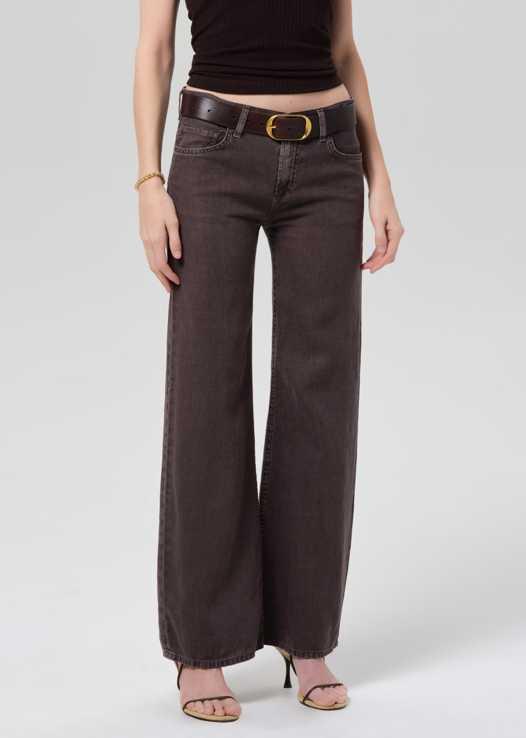 Person wearing a dark brown halter top and charcoal wide-leg linen pants on a plain background 