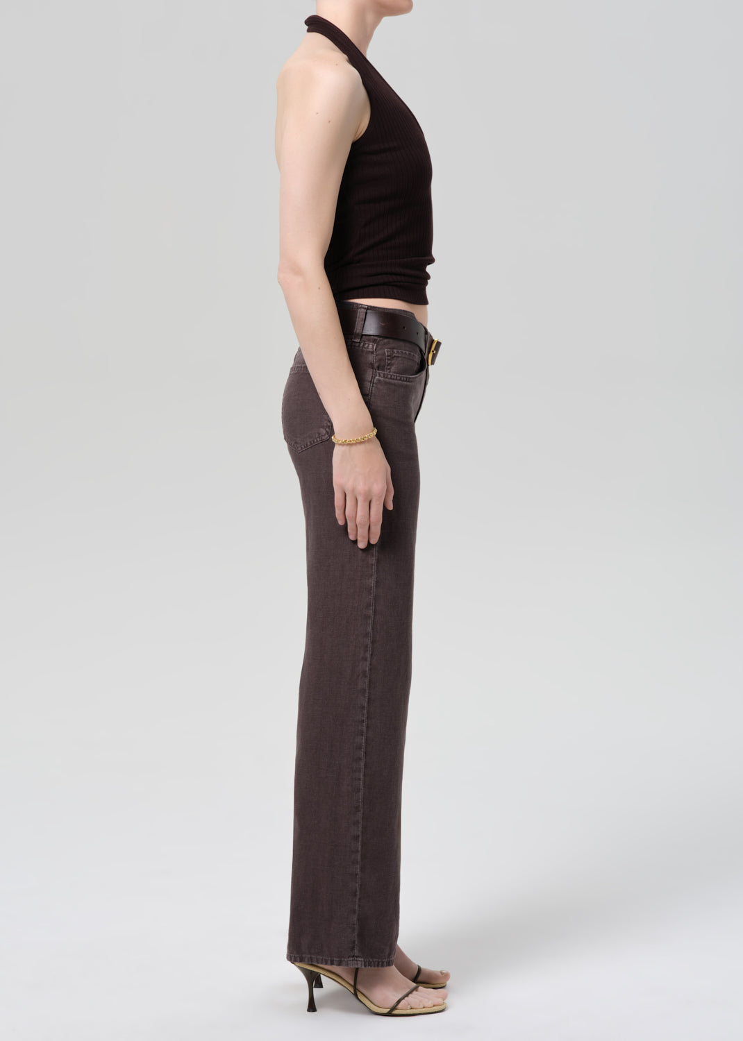 Person wearing a dark brown halter top and charcoal wide-leg linen pants on a plain background 