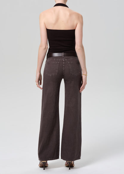 Person wearing a dark brown halter top and charcoal wide-leg linen pants on a plain background 