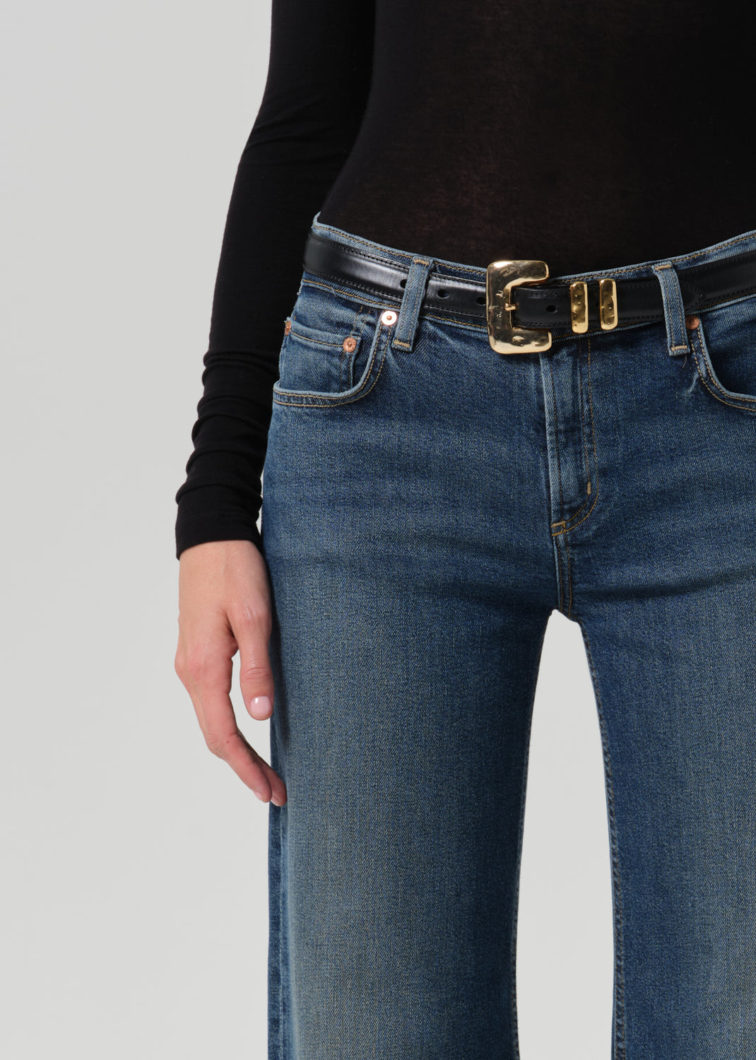 Close up of blue pant and black belt on grey background