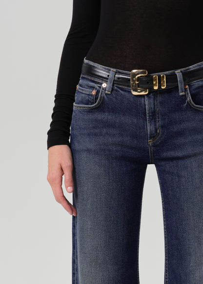 Close-up of dark blue wide leg jeans showing the waistband, front pockets, belt, and subtle fading.