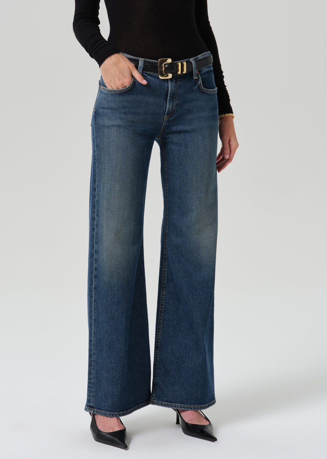 Close up of blue pant and black belt on a grey background