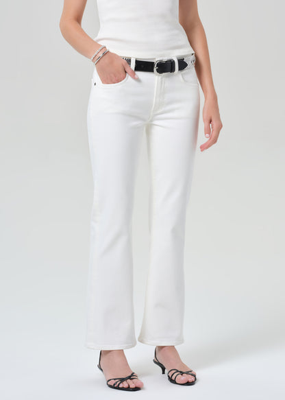 Person wearing white pants with a black belt on a grey background