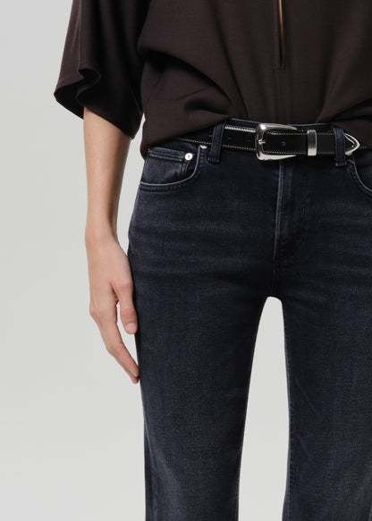 Close up of brown shirt on blue jeans on a grey background