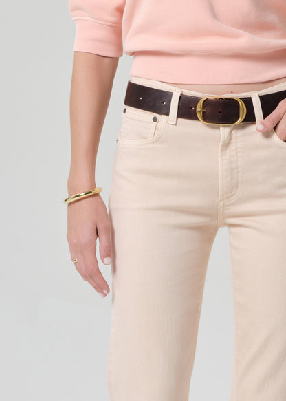 Person wearing a pink sweatshirt and light pink jeans on a grey background
