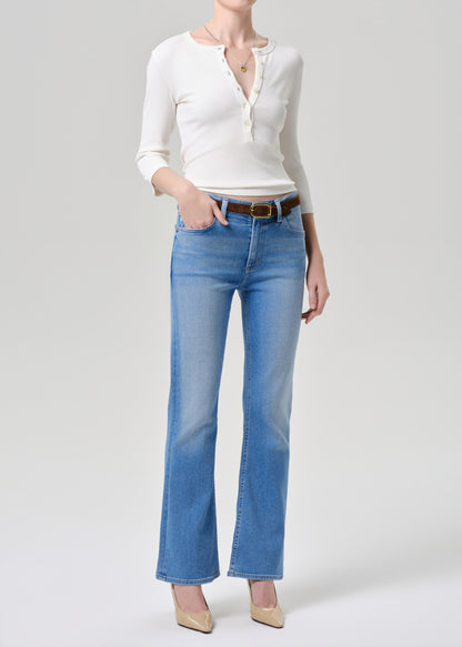 Person wearing a white shirt and blue jeans on a grey background