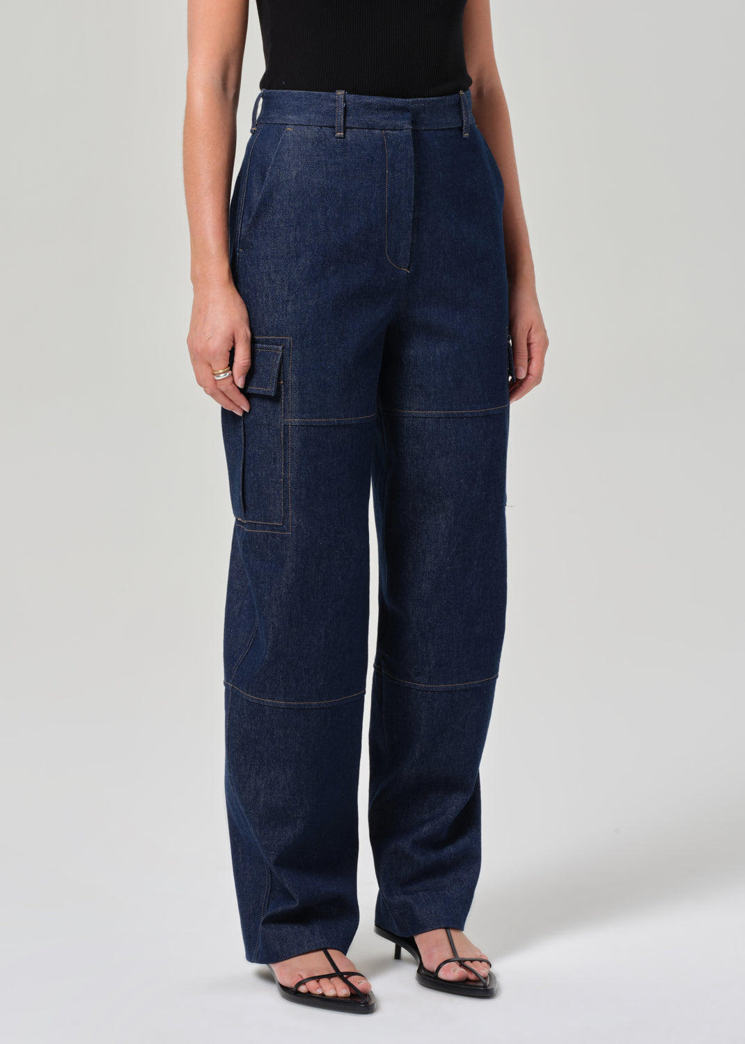 Person wearing dark blue cargo pants on a plain background