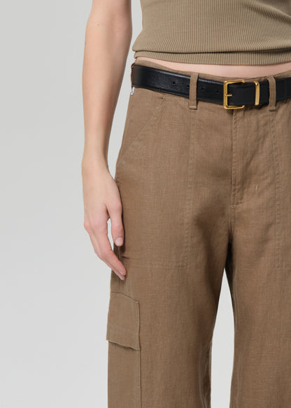 Person wearing brown cargo pants with a black belt on a light gray background