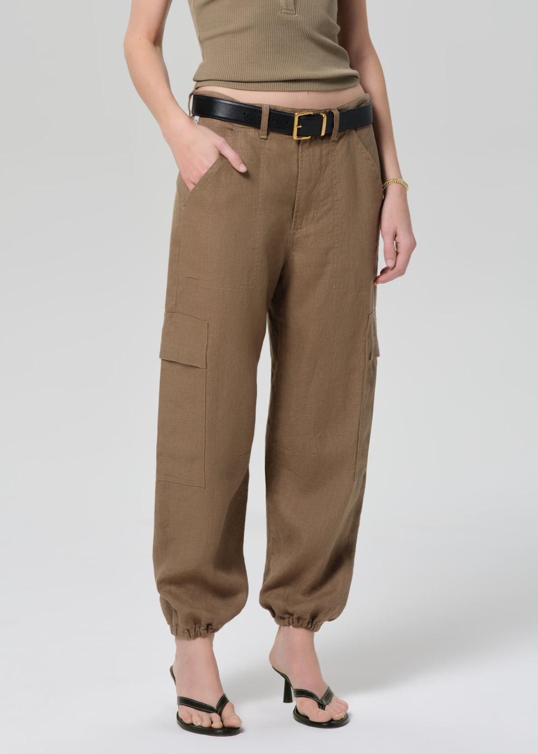 Person wearing brown cargo pants on a plain background