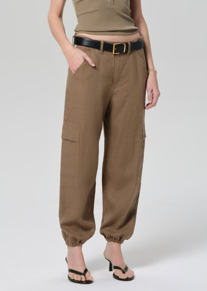 Person wearing brown cargo pants on a plain background
