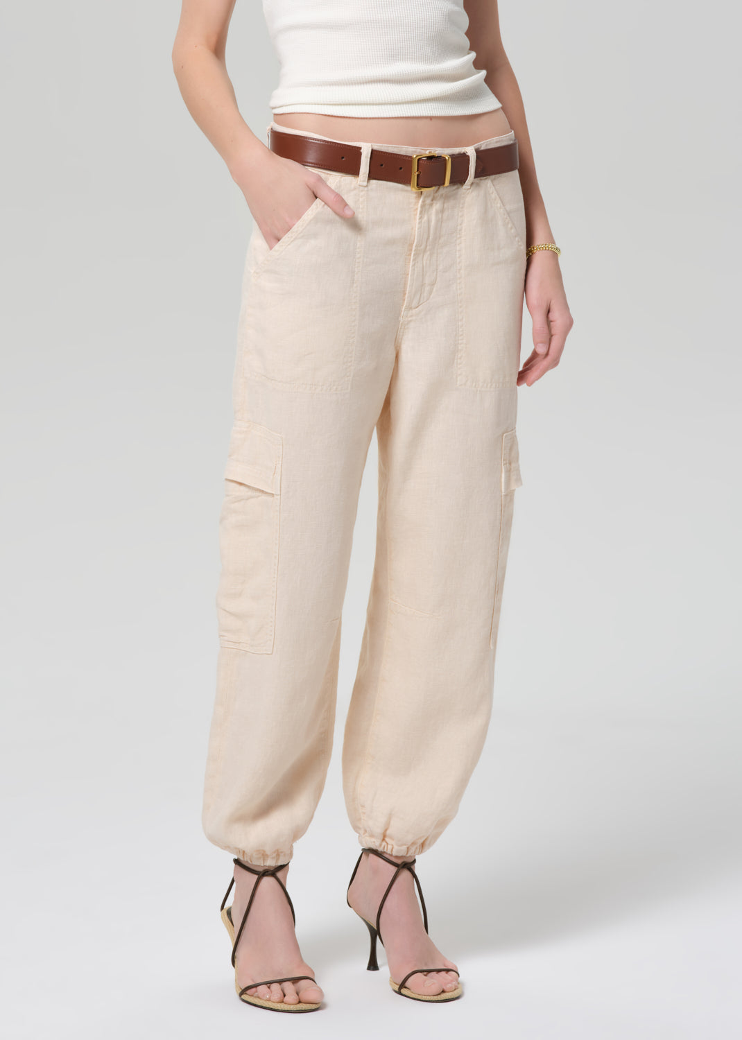 Beige pants worn by a person on a white background