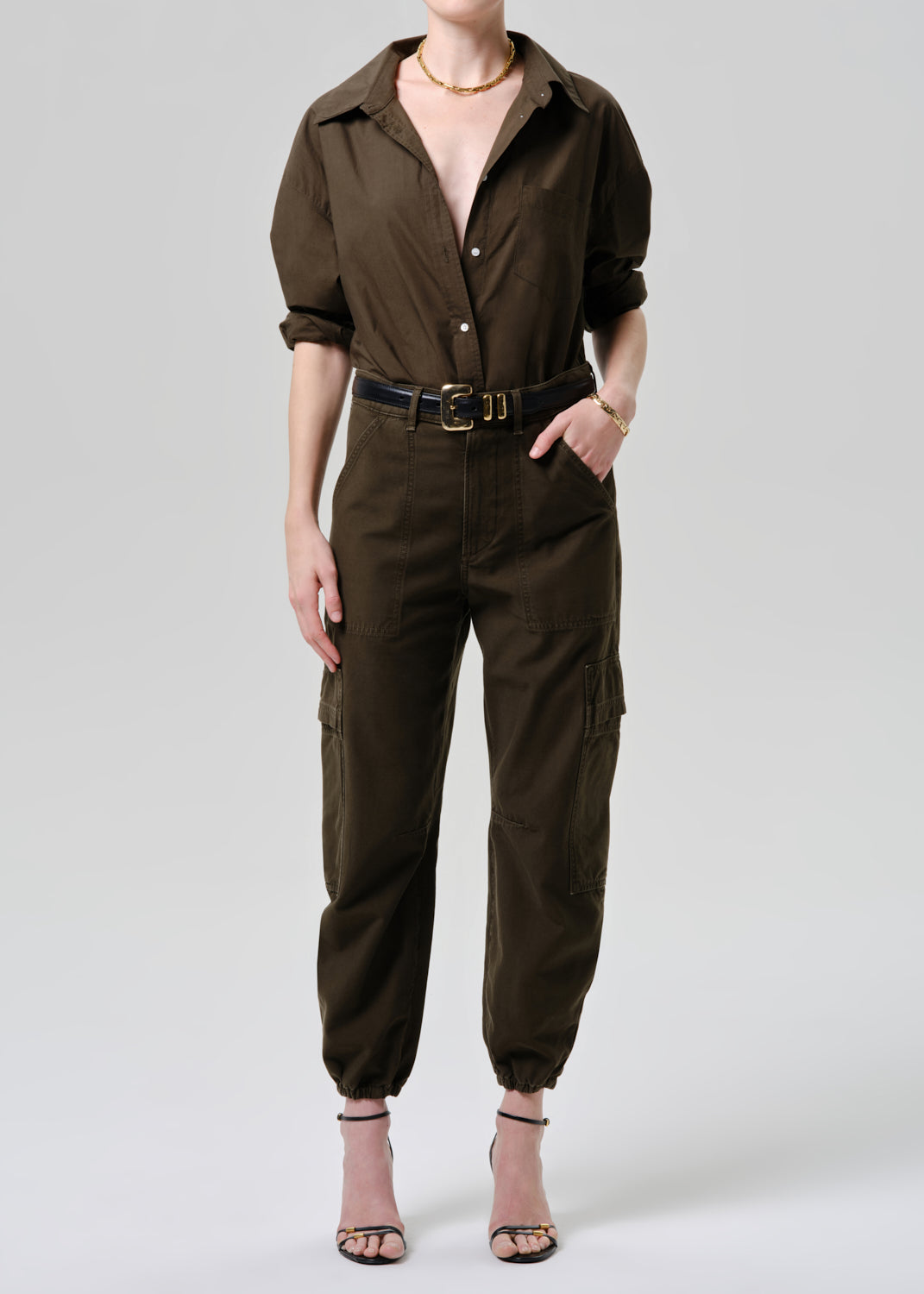 Person wearing a brown jumpsuit on a grey background