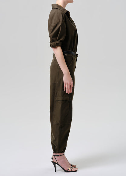 Person wearing a green jumpsuit on a grey background