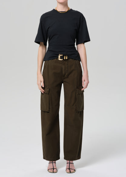 Person wearing a black t-shirt and green cargo pants on a light gray background