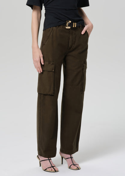 Person wearing a black t-shirt and green cargo pants on a light gray background