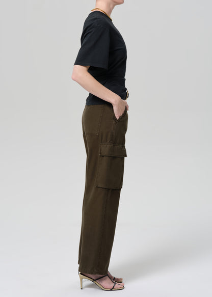 Person wearing a black t-shirt and green cargo pants on a light gray background