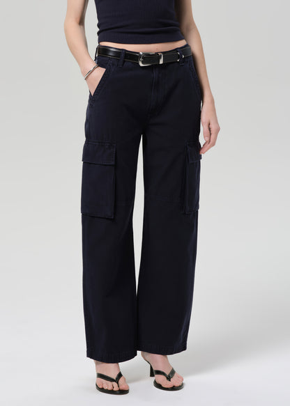 Person wearing a navy tee and navy cargo pants with a belt on a grey background