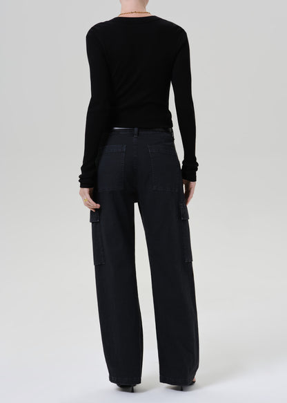 A model shown from the back wearing a black long-sleeve top and black wide-leg cargo pants against a grey background.