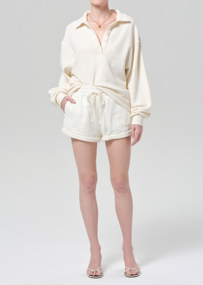 Person wearing a cream-colored outfit on a plain background