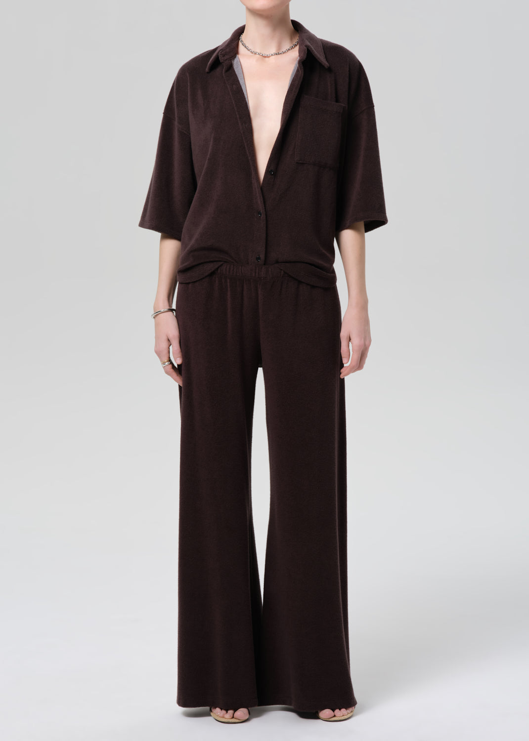 Person wearing a brown terry set on a grey background