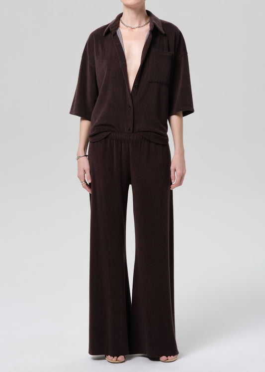 Person wearing a brown terry set on a grey background