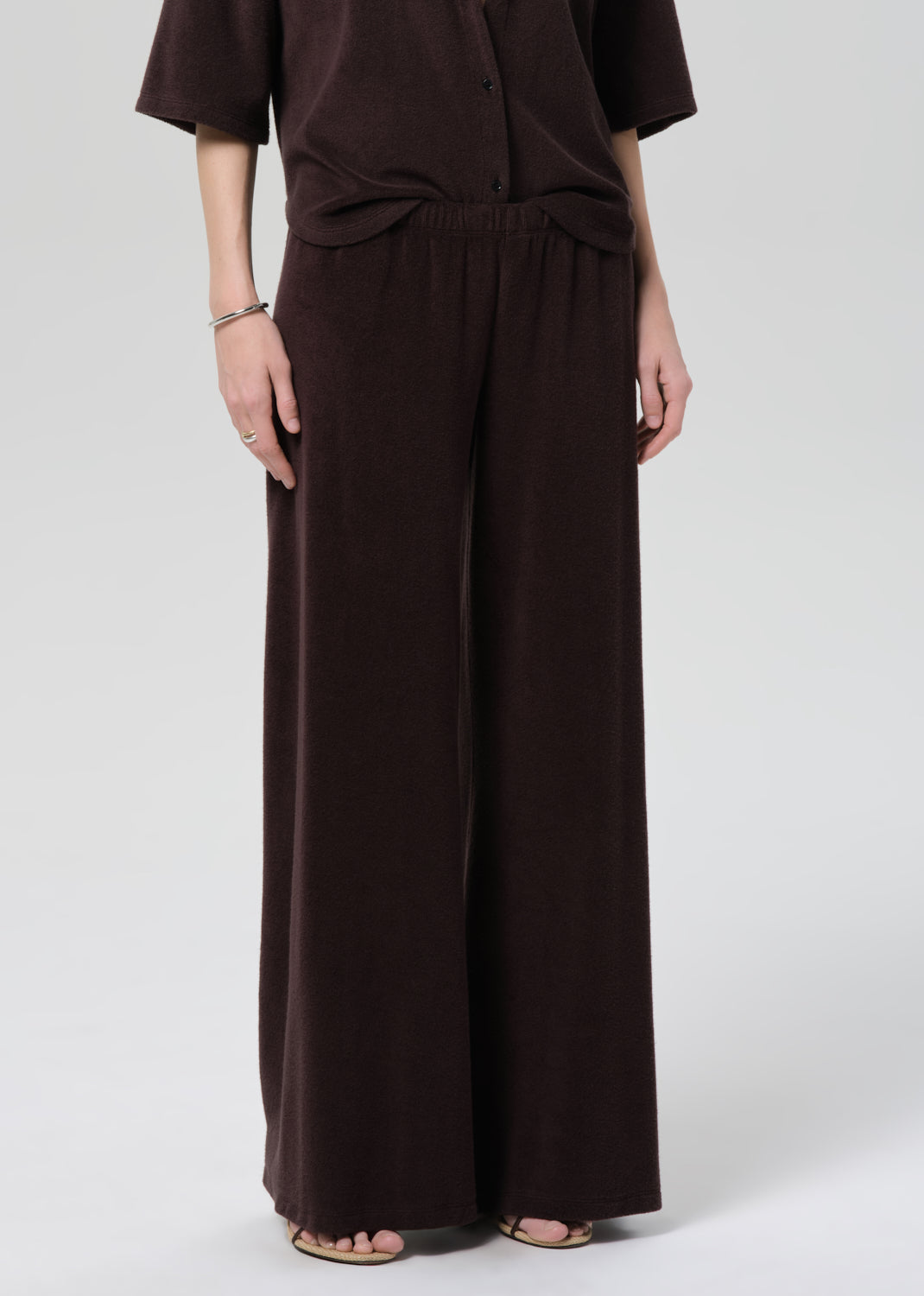 Person wearing a brown terry set on a grey background