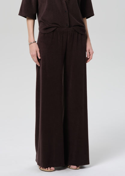 Person wearing a brown terry set on a grey background