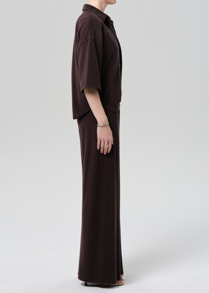 Person wearing a brown terry set on a grey background