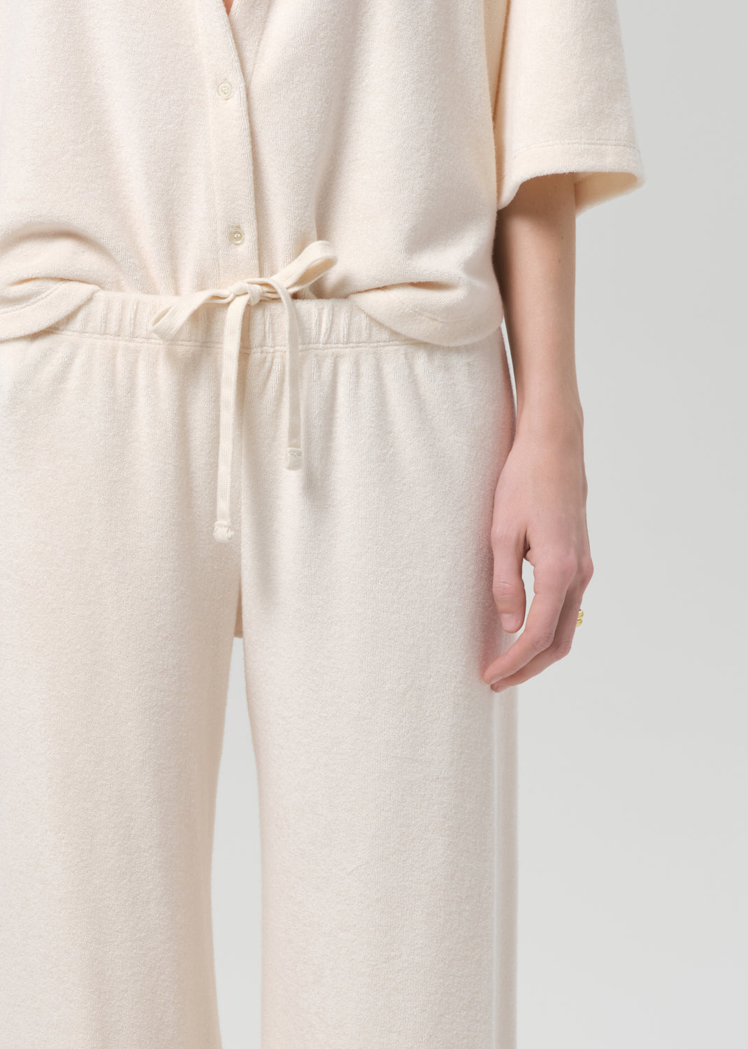 Woman wearing a cream terry outfit on a plain background