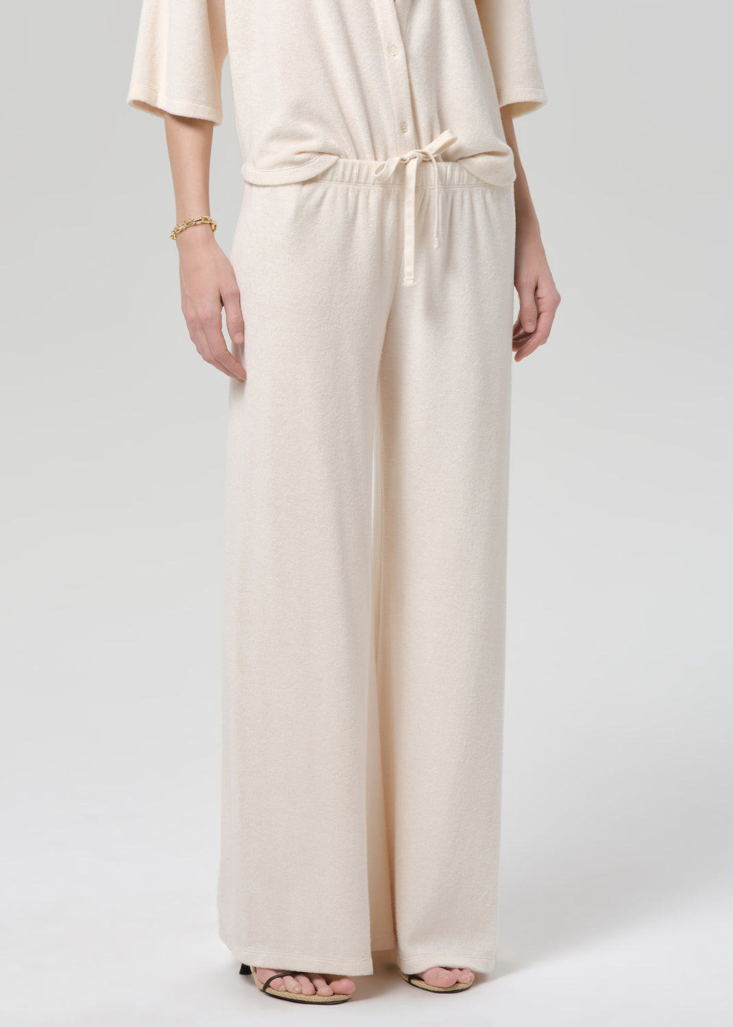 Woman wearing a cream terry outfit on a plain background