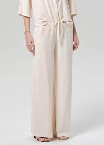 Woman wearing a cream terry outfit on a plain background