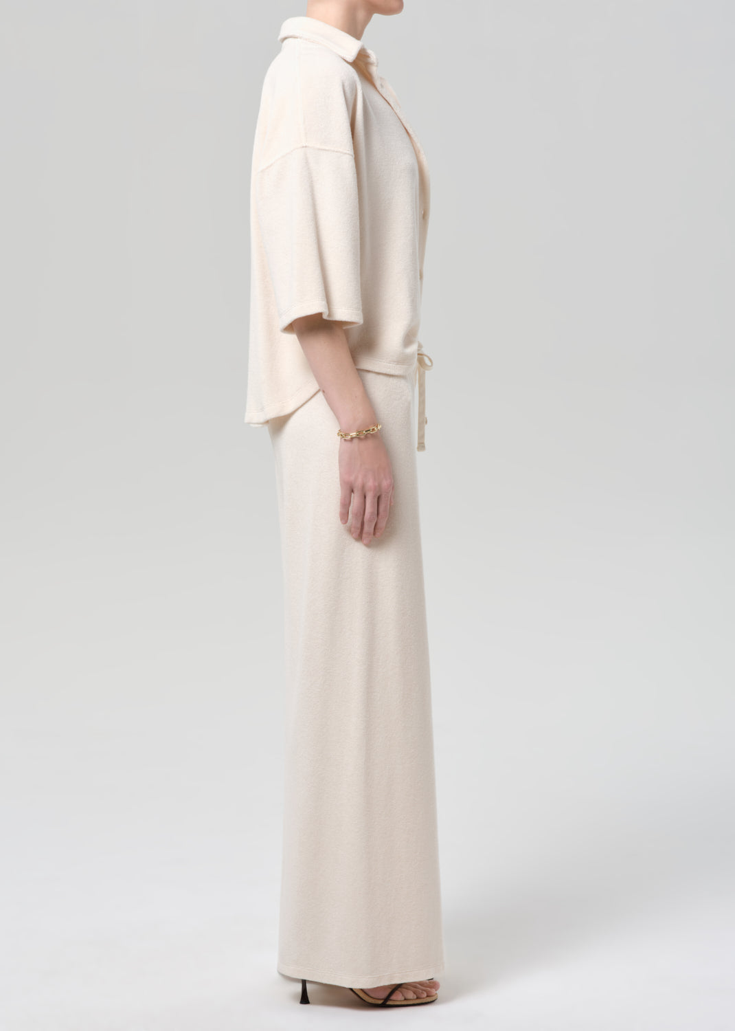 Woman wearing a cream terry outfit on a plain background