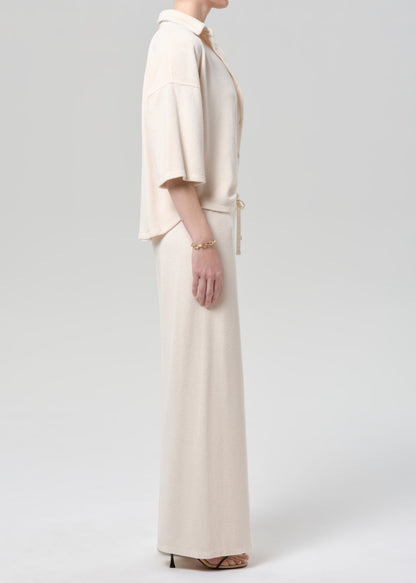 Woman wearing a cream terry outfit on a plain background