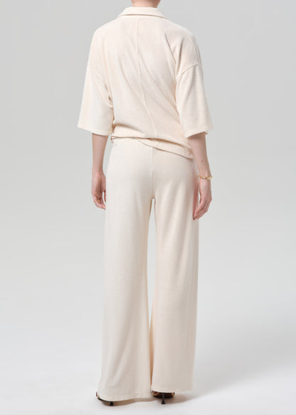 Woman wearing a cream terry outfit on a plain background