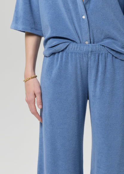 Person wearing a blue terry outfit on a light gray background
