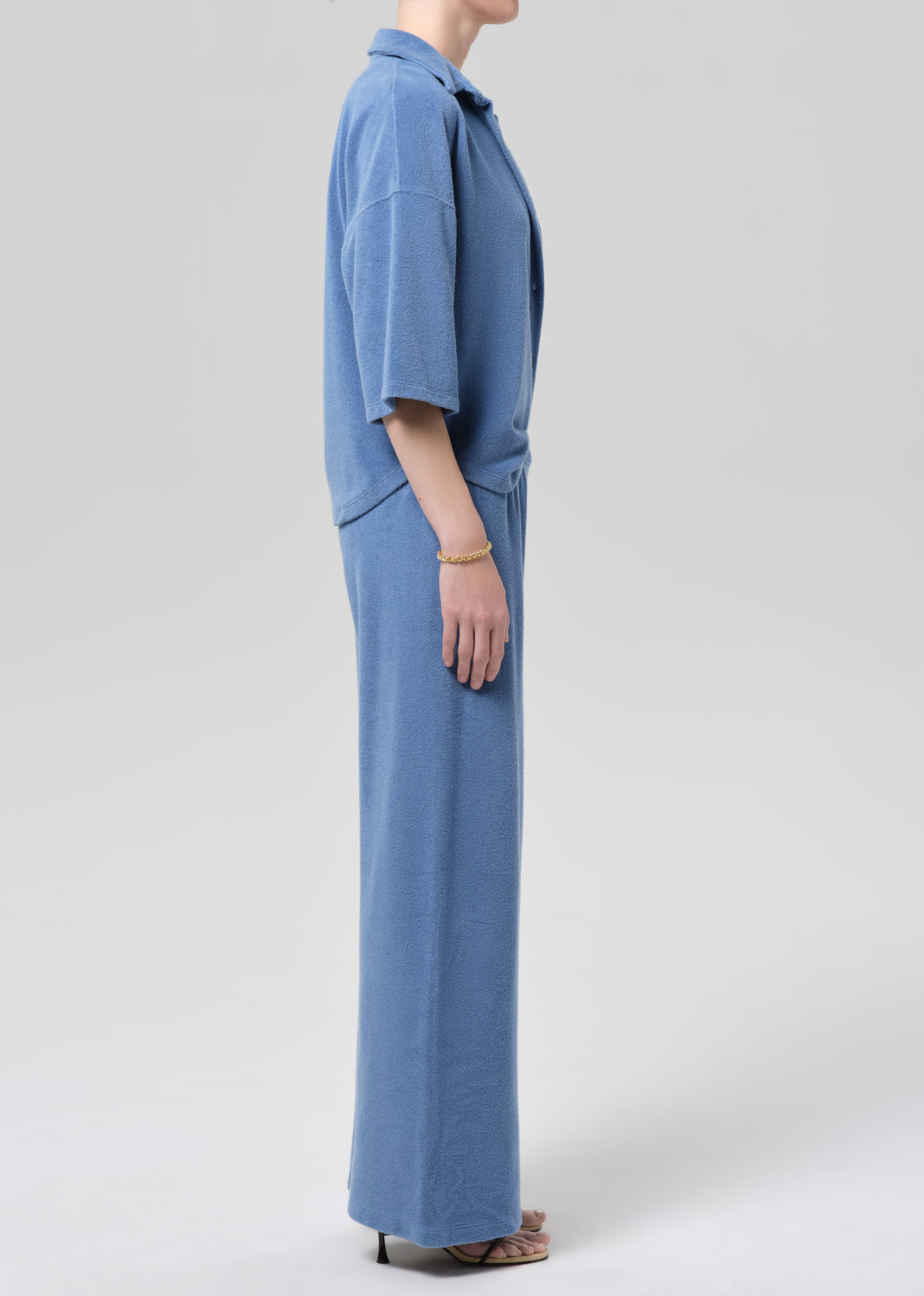 Person wearing a blue terry outfit on a light gray background