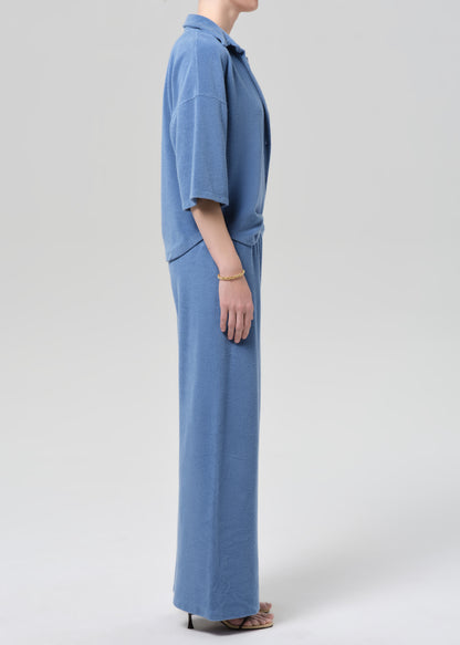 Person wearing a blue terry outfit on a light gray background