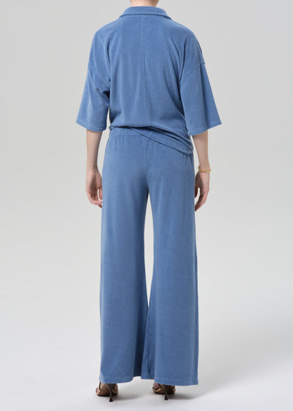 Person wearing a blue terry outfit on a light gray background