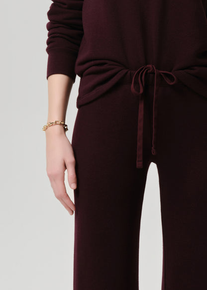Burgundy outfit with a tied waist on a grey background
