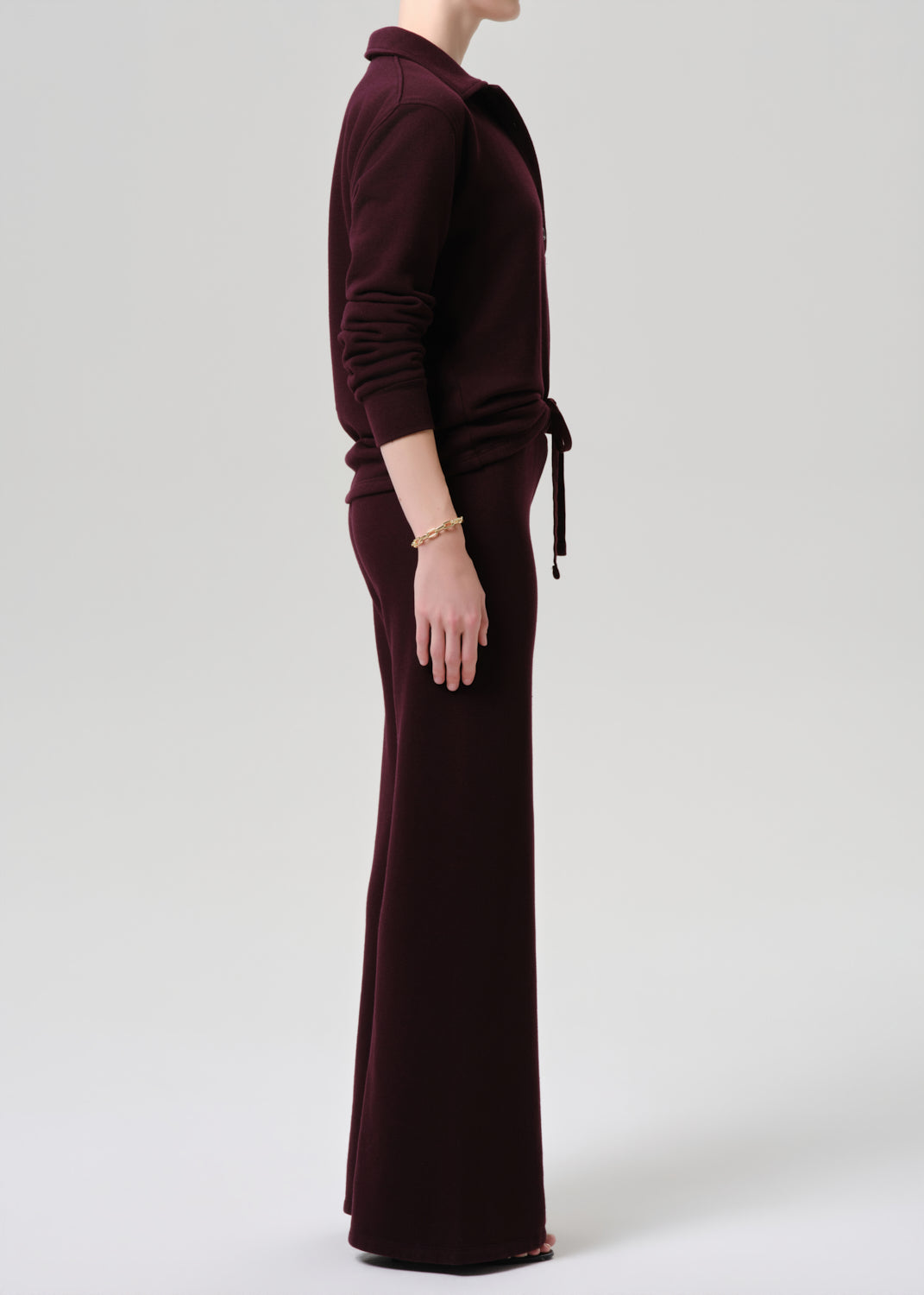 Person wearing a burgundy outfit on a grey background
