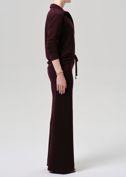Person wearing a burgundy outfit on a grey background