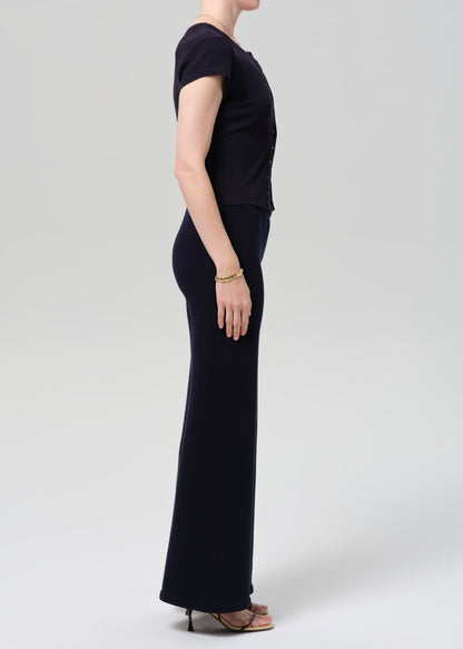 Person wearing a navy outfit with a buttoned top and wide-leg pants on a plain background